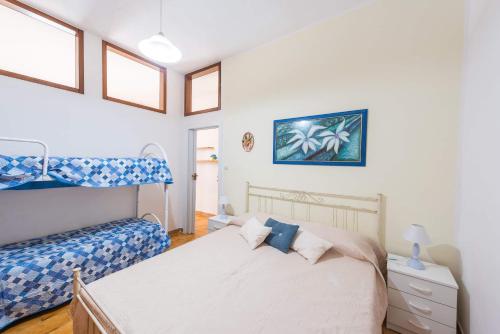 マリッティマにあるCasa vacanze Baia Acquavivaのベッドルーム1室(ベッド1台、二段ベッド1組付)