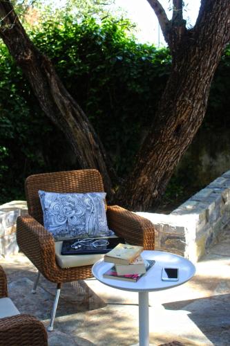 a wicker chair and a table with a book at Agape in Kala Nera