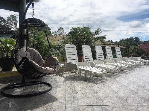 a row of white lawn chairs and a swing at La Terraza Verde in Drake