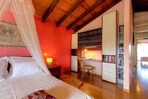 1 dormitorio con paredes rojas y 1 cama con dosel en The Red Bougainvillea Apartments en Corfú