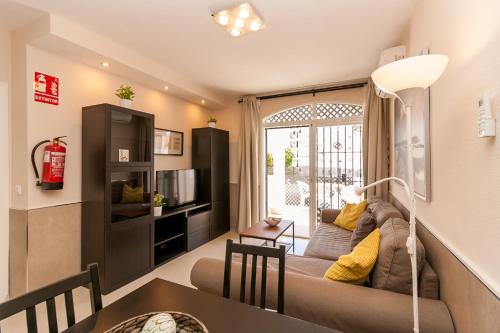 a living room with a couch and a table at Verano Azul 61B Nerja in Nerja