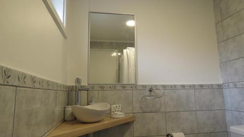 a bathroom with a sink and a mirror at Apart Costanera in Villa Pehuenia
