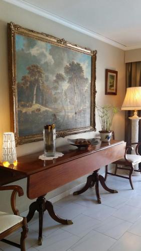a table in a room with a painting on the wall at ADOSADO DE LUJO CON PISCINA PRIVADA en ZONA MUY TRANQUILA in Gandía