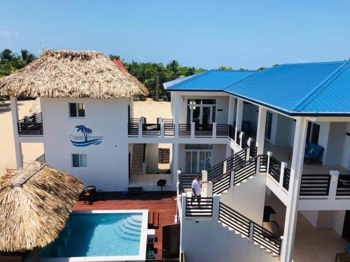 a house on the beach with a swimming pool at Ocean Breeze in Placencia Village