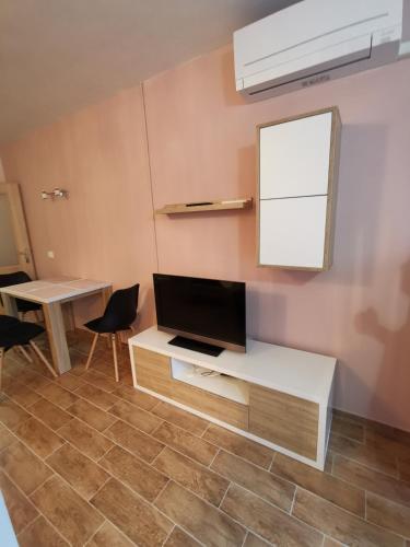 a living room with a tv and a table and chairs at Apartma F&M in Bovec