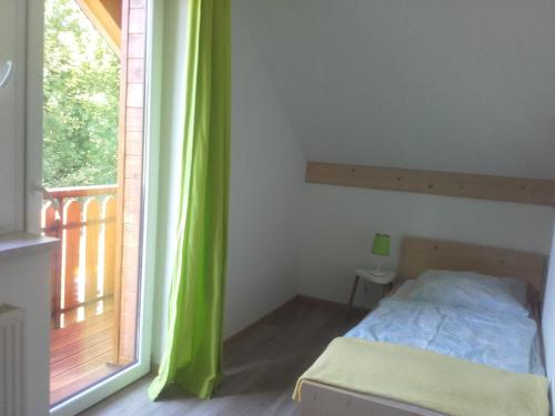 a bedroom with a bed and a large window at Domki Partecznik Wisla in Wisła