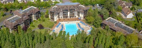 - une vue aérienne sur un grand bâtiment avec une piscine dans l'établissement LA RESIDENCE DU GOLF DE DEAUVlLLE, à Deauville