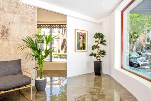 a living room with a couch and plants at Wake Up Famalicão in Vila Nova de Famalicão