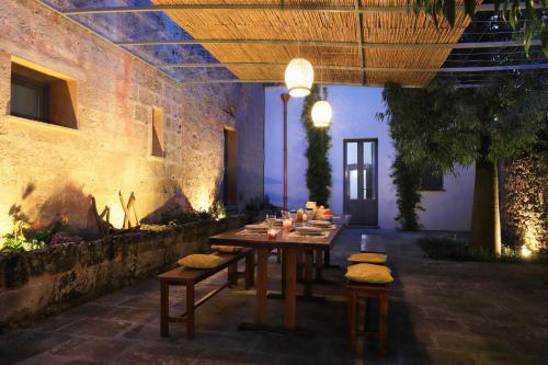 a wooden table in a room with a table and chairs at Masseria delle Pecore in Specchia