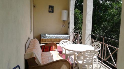 a balcony with chairs and a table and a table and chairs at Toma's vila in Borjomi
