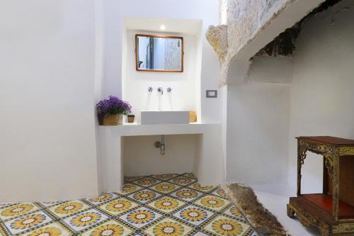 baño con lavabo y suelo de baldosa. en Masseria delle Pecore, en Specchia