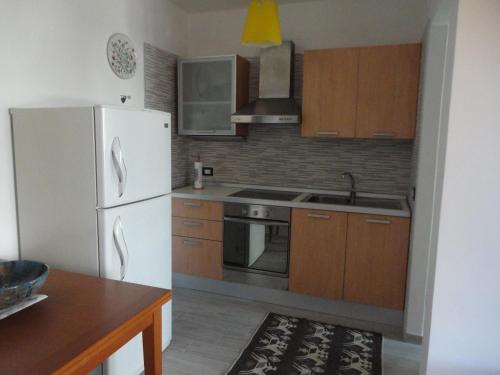 a kitchen with a white refrigerator and wooden cabinets at Sardinia Holidays - Domus Patrizia in Quartu SantʼElena