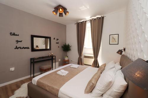 a bedroom with a large bed and a mirror at Cicibela Apartment - Zadar in Zadar
