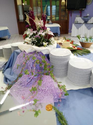 a table with white plates and flowers on it at Camping Village La Pineta in San Vito lo Capo