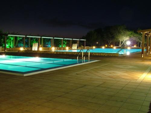 a swimming pool at night with lights at Camping Village La Pineta in San Vito lo Capo
