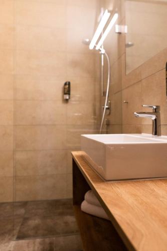 a bathroom with a white sink and a mirror at Rossano Boutique Hotel & Ristorante in Ansbach