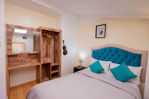 a bedroom with a large bed with a blue headboard at Cozy Room Cusco in Cusco