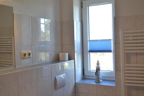 baño con urinario y ventana en Haus Simone, en Poel