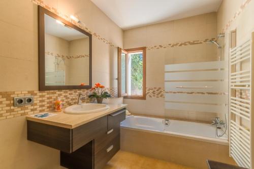 a bathroom with a sink and a tub and a mirror at Portocolom - 2618-36 Mallorca in Portocolom