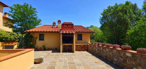 a house with a stone wall and a fence at Torrebianca Tuscany in Rignano sullʼArno