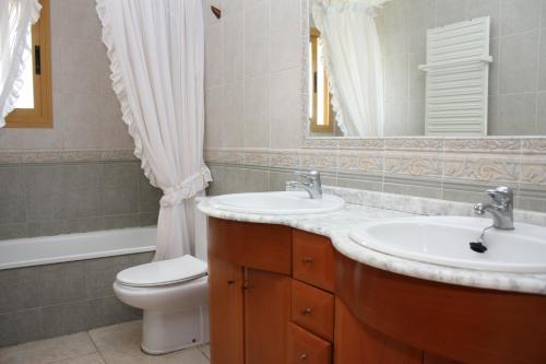 a bathroom with a sink and a toilet and a mirror at Adosado Peñisol Inmomart in Peniscola