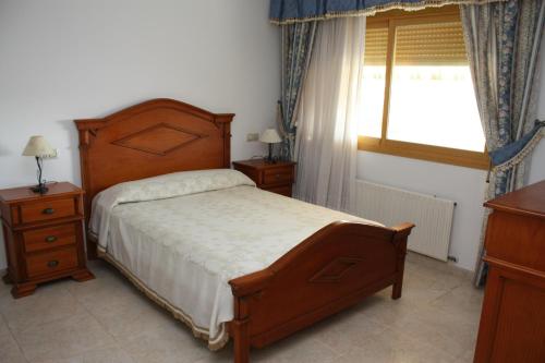 a bedroom with a large bed and a window at Adosado Peñisol Inmomart in Peniscola
