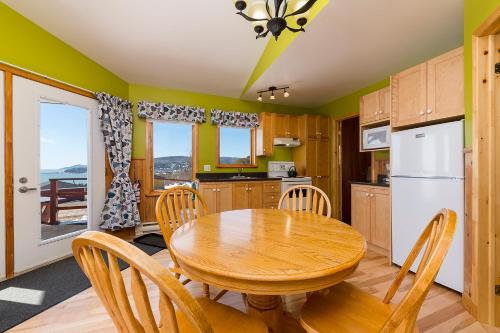 a kitchen and dining room with a wooden table and chairs at Domaine Frais Air in La Malbaie