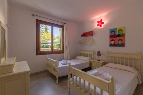 a bedroom with two beds and a window at Playa de Muro - 266031 in Playa de Muro