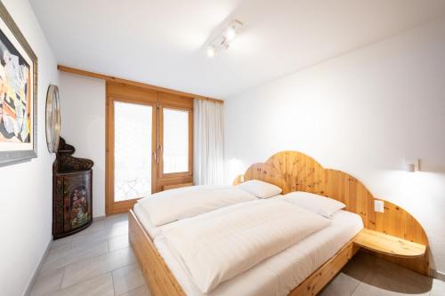 um quarto com uma cama grande e uma cabeceira em madeira em LAAX Homes - Runca 752 em Flims