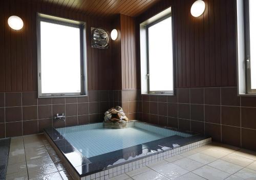 a large bathroom with a hot tub with two windows at Hotel Ocean Iwasawa / Vacation STAY 33555 in Kido
