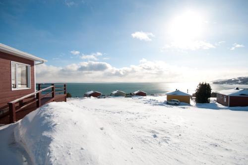 a snow covered porch of a house with a view of the water at Domaine Frais Air in La Malbaie