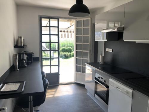 a kitchen with a black counter top and a window at Angel Services - LA MAISON DE LA PLAGE in Sévrier