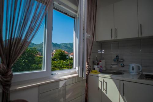 a kitchen with a window with a view of the mountains at Guesthouse Buco in Trebinje