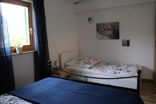 a small bedroom with a bed and a window at Apartment Lilly in Nerezine