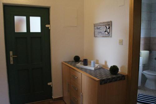 a bathroom with a black door and a toilet at Apartment Lilly in Nerezine
