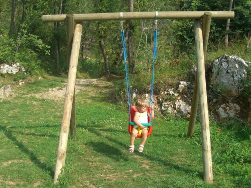 a little girl sitting on a swing at Maso Salim Relax Apartments in Drena