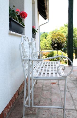 two white chairs sitting next to a building at Rábagyarmati Apartman II in Rábagyarmat