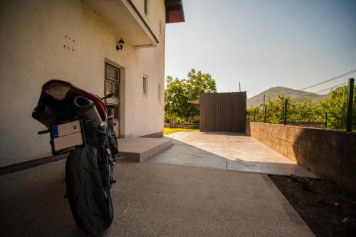 a motorcycle parked next to a building at Guesthouse Buco in Trebinje