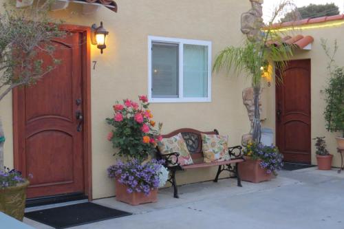 a bench sitting in front of a house with flowers at Leucadia Beach Inn in Encinitas