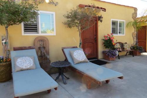 two chairs and a table in front of a house at Leucadia Beach Inn in Encinitas