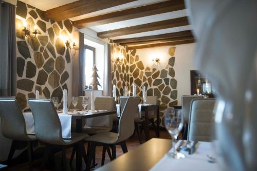 a restaurant with several tables and chairs and a window at Rossano Boutique Hotel & Ristorante in Ansbach
