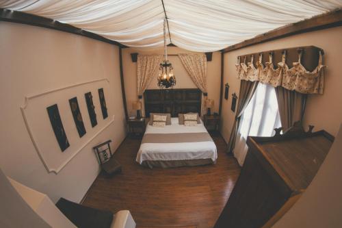 a bedroom with a bed and a piano in a room at Roka Plaza Hotel Boutique in Ambato