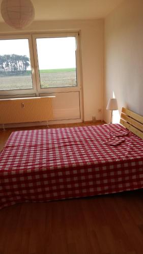 a bedroom with a bed with a red plaid blanket at Natur-Freude-16 in Kotzen