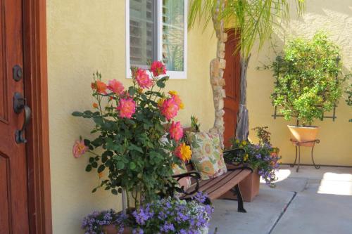 a porch with a bench with flowers on it at Leucadia Beach Inn in Encinitas