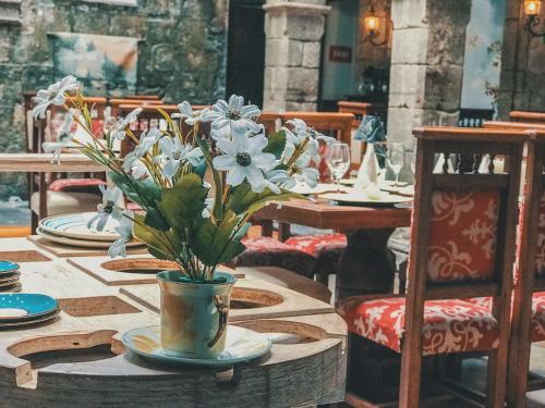 a table with a vase of white flowers on it at Roka Plaza Hotel Boutique in Ambato