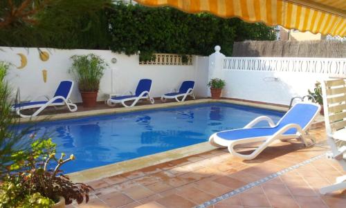 a swimming pool with lounge chairs and an umbrella at ADOSADO DE LUJO CON PISCINA PRIVADA en ZONA MUY TRANQUILA in Gandía