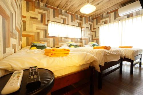 a bedroom with two beds and a remote control at Takayama - Apartment / Vacation STAY 34382 in Takayama