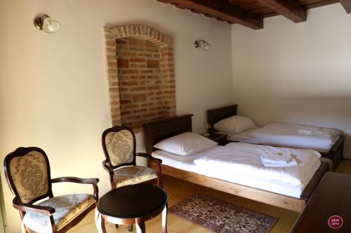 a room with two beds and two chairs and a table at Rábagyarmati Apartman II in Rábagyarmat