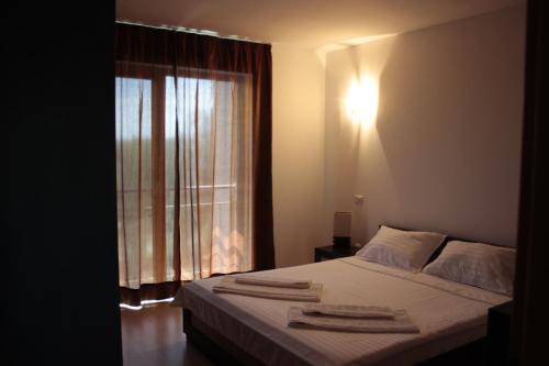 a bedroom with a bed and a window with towels on it at SeaSide Piano Bar Apartament in Mamaia