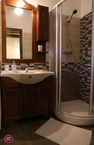 a bathroom with a sink and a shower at Rábagyarmati Apartman II in Rábagyarmat